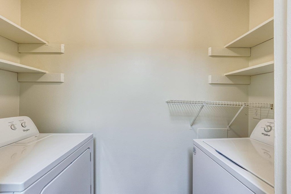 A white laundry room with a washer and dryer on each side.