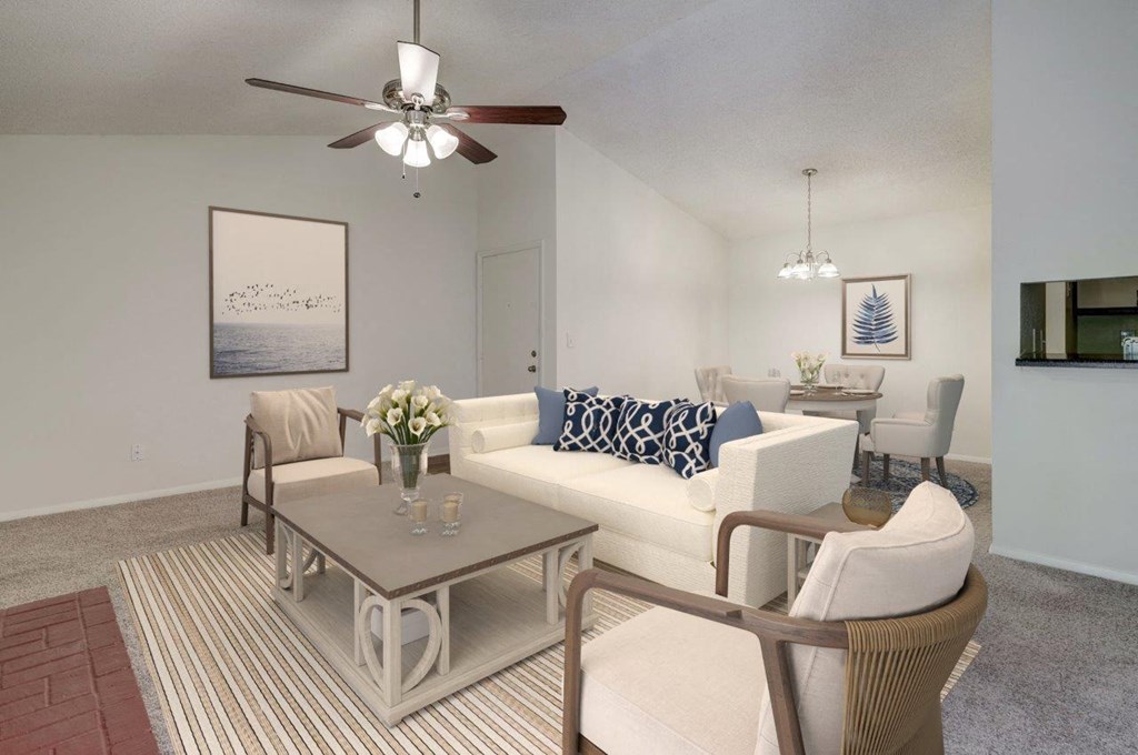 A living room with a white couch, a coffee table, and a ceiling fan.