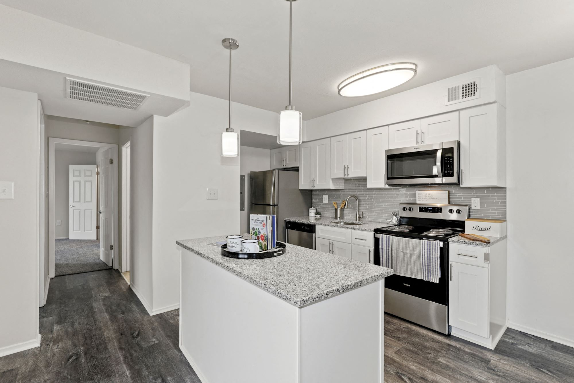 a kitchen with white cabinets and stainless steel appliances
