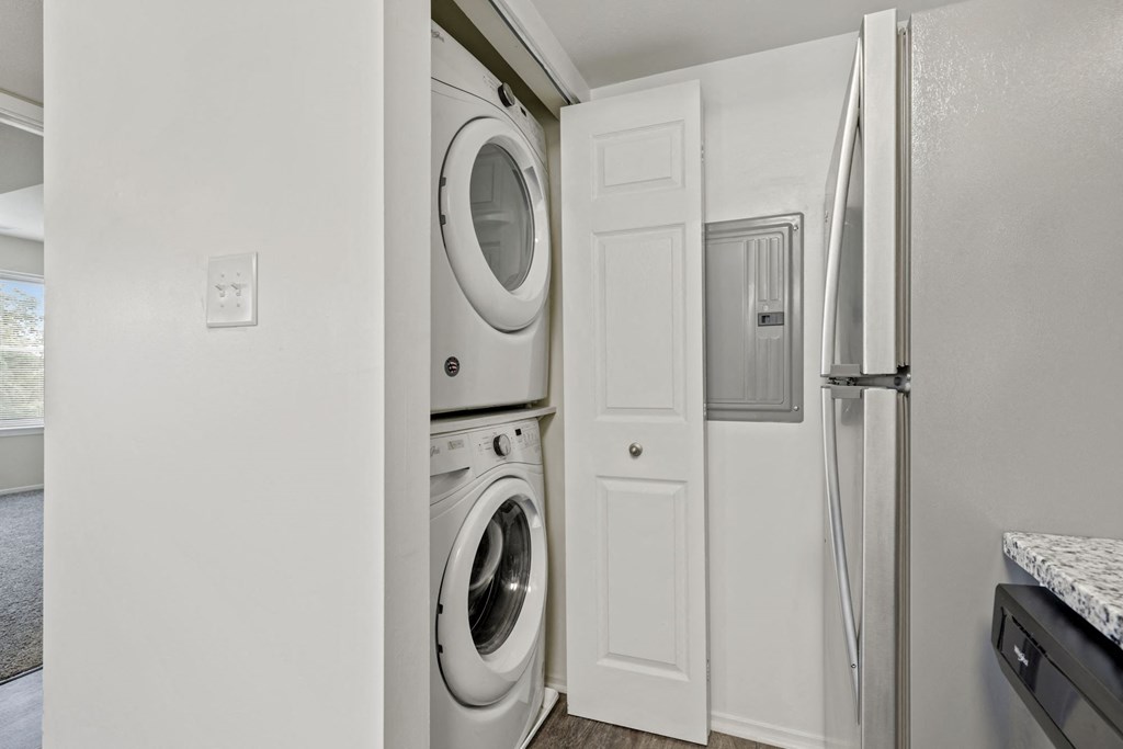 a white washer and dryer in a white laundry room with a white door