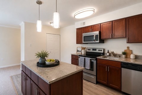 A kitchen with brown cabinets and a granite countertop.