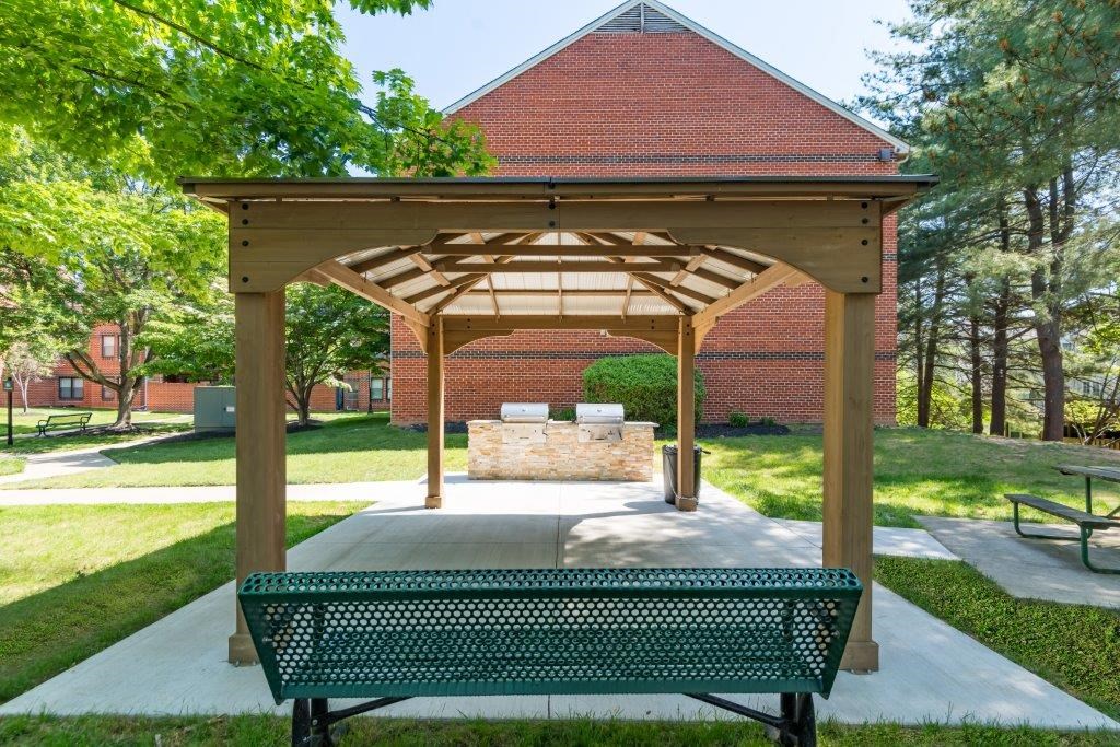 a picnic area with a bench and a gazebo