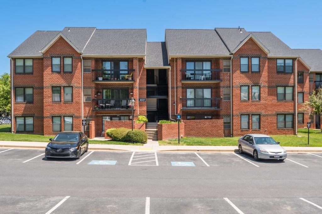 a large brick apartment building with cars parked in a parking lot