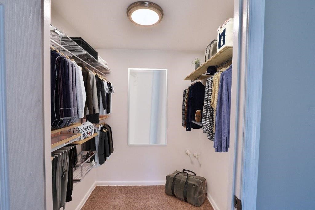 a closet with some clothes and a suitcase