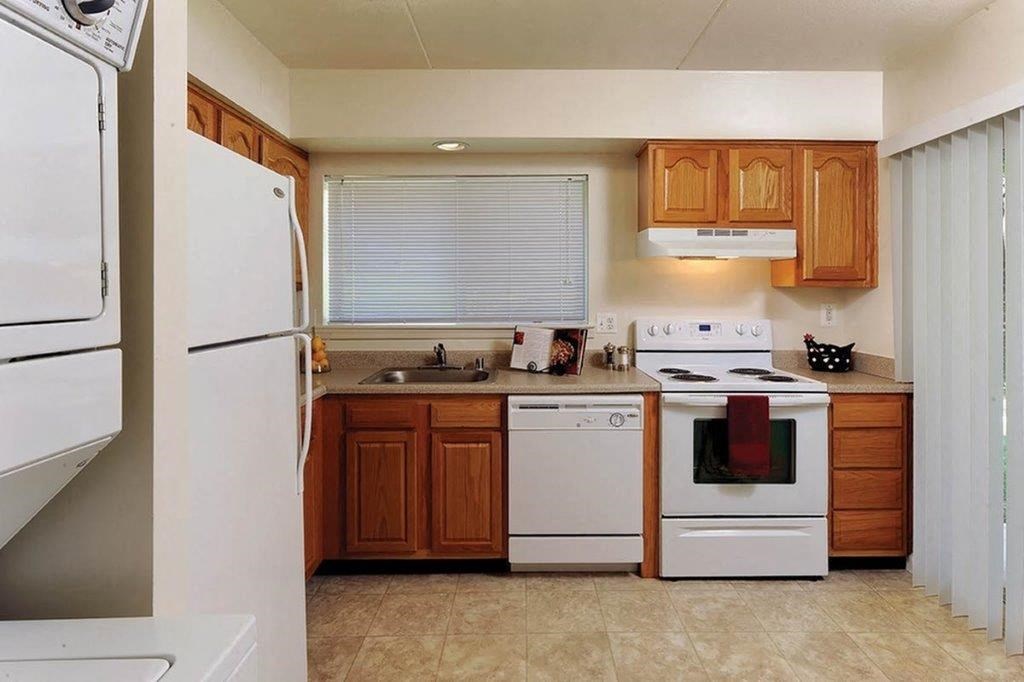 a kitchen with white appliances and wooden cabinets
