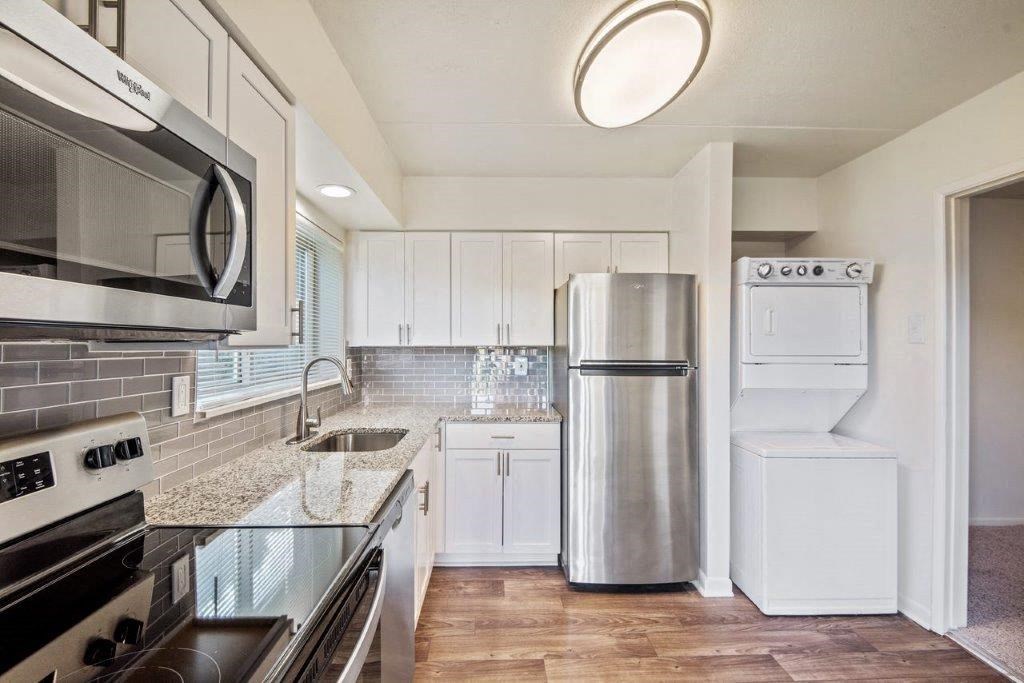 a kitchen with white cabinets and a stainless steel refrigerator