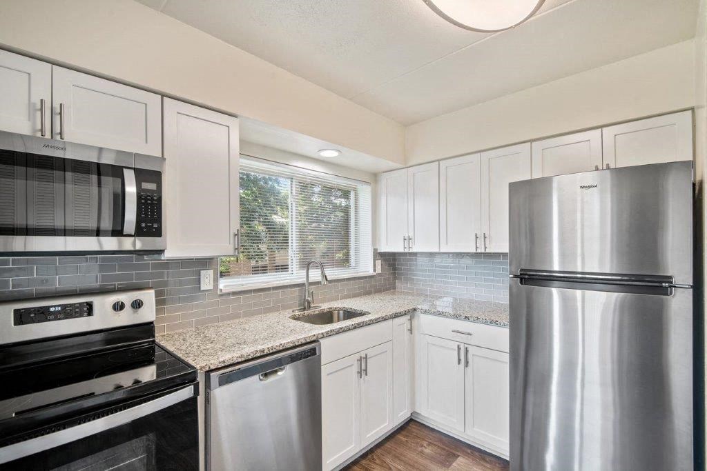 a kitchen with stainless steel appliances and white cabinets