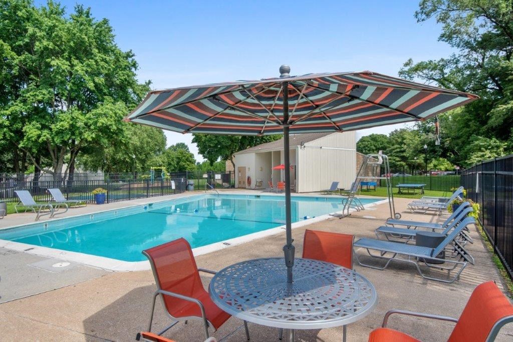 our apartments have a pool and a patio with chairs and a table
