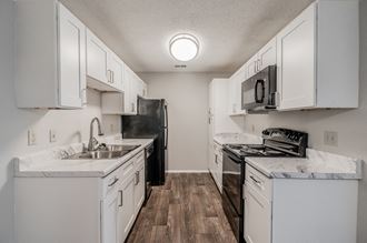 the preserve at ballantyne commons apartment kitchen with white cabinets and stainless steel appliances