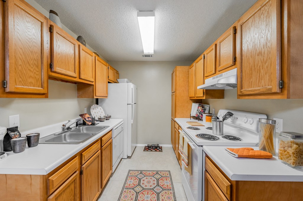 a kitchen with white appliances and wooden cabinets