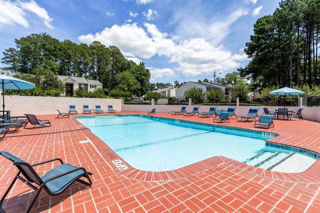 a swimming pool with chairs and umbrellas