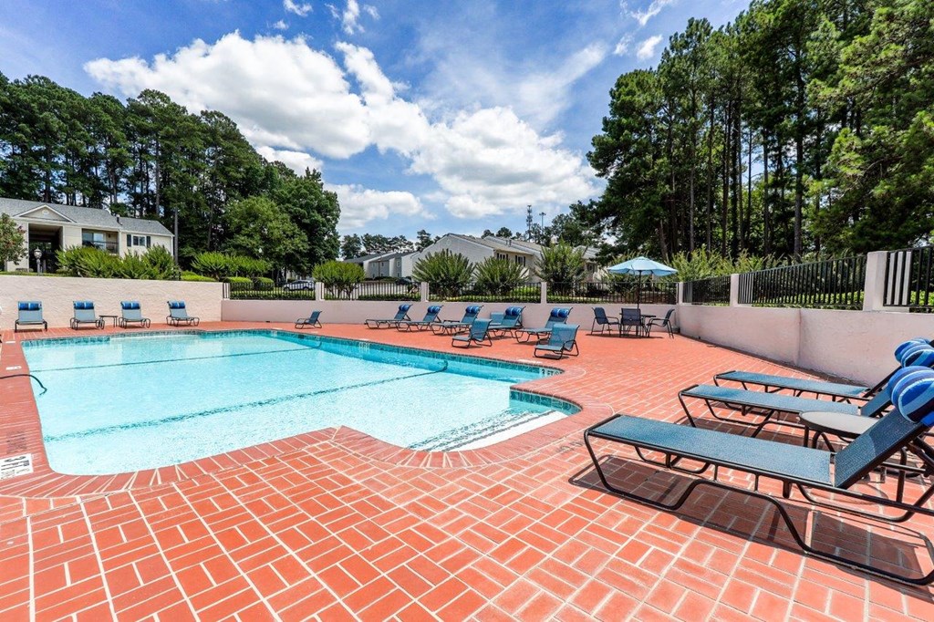 a resort style pool with lounge chairs and trees