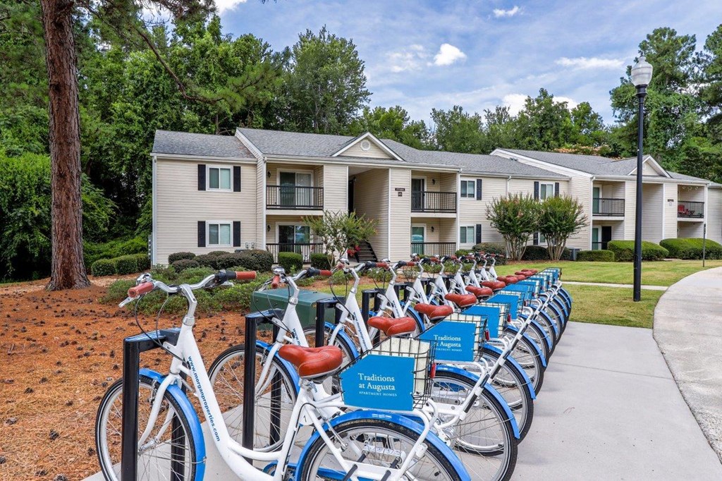a row of bikes parked in front of an apartment building