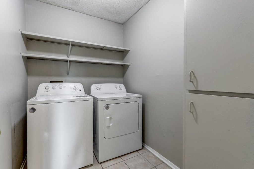 a washer and dryer in a laundry room with a shelf above
