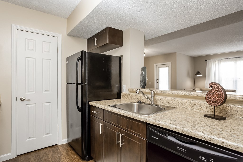 an empty kitchen with a sink and a refrigerator