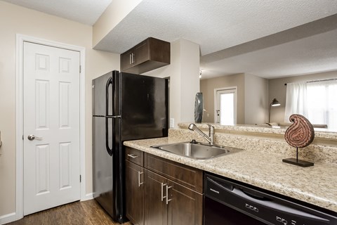 an empty kitchen with a sink and a refrigerator