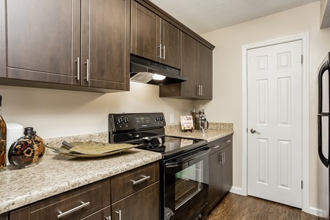 an updated kitchen with black appliances and granite counter tops