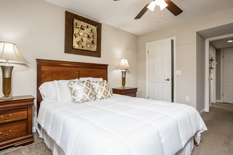 a bedroom with a large bed and a ceiling fan