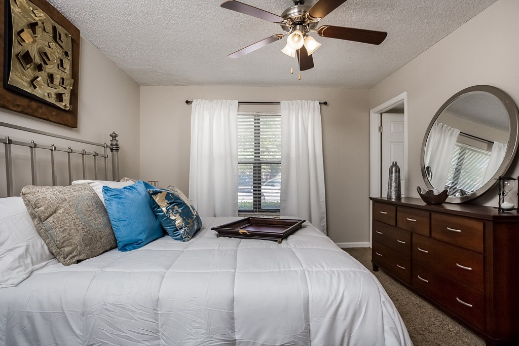 the master bedroom has a large bed and a ceiling fan