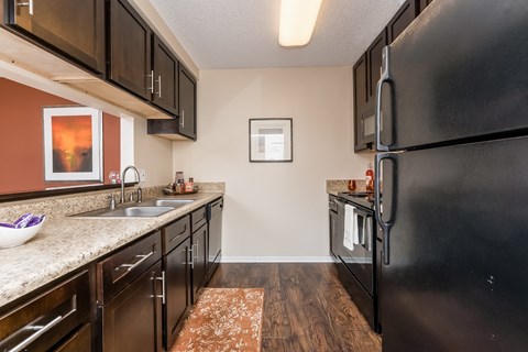the kitchen of a home with black appliances and granite counter tops