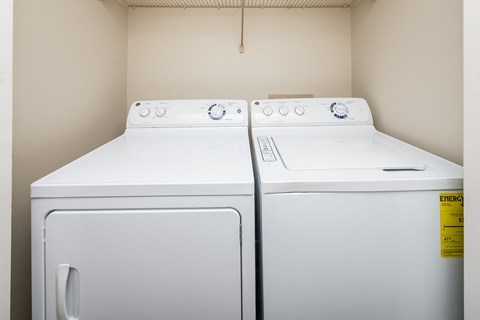 two washes and dryers in the laundry room of an apartment