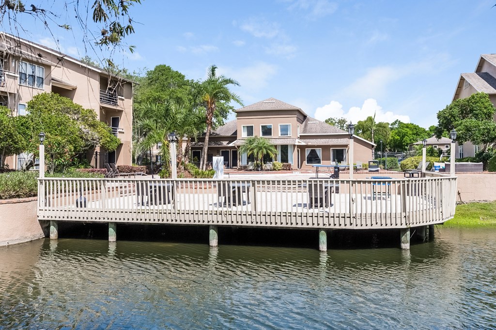 a white bridge over the water in front of a house