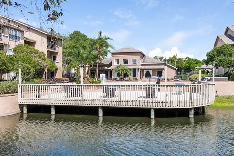 a white bridge over the water in front of a house