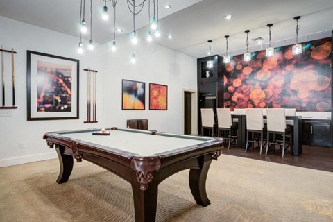 a games room with a pool table and a dining area
