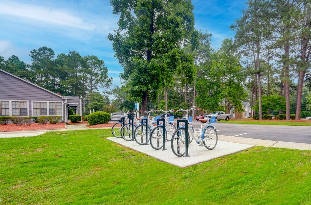 a row of bikes parked on a sidewalk in front of a house
