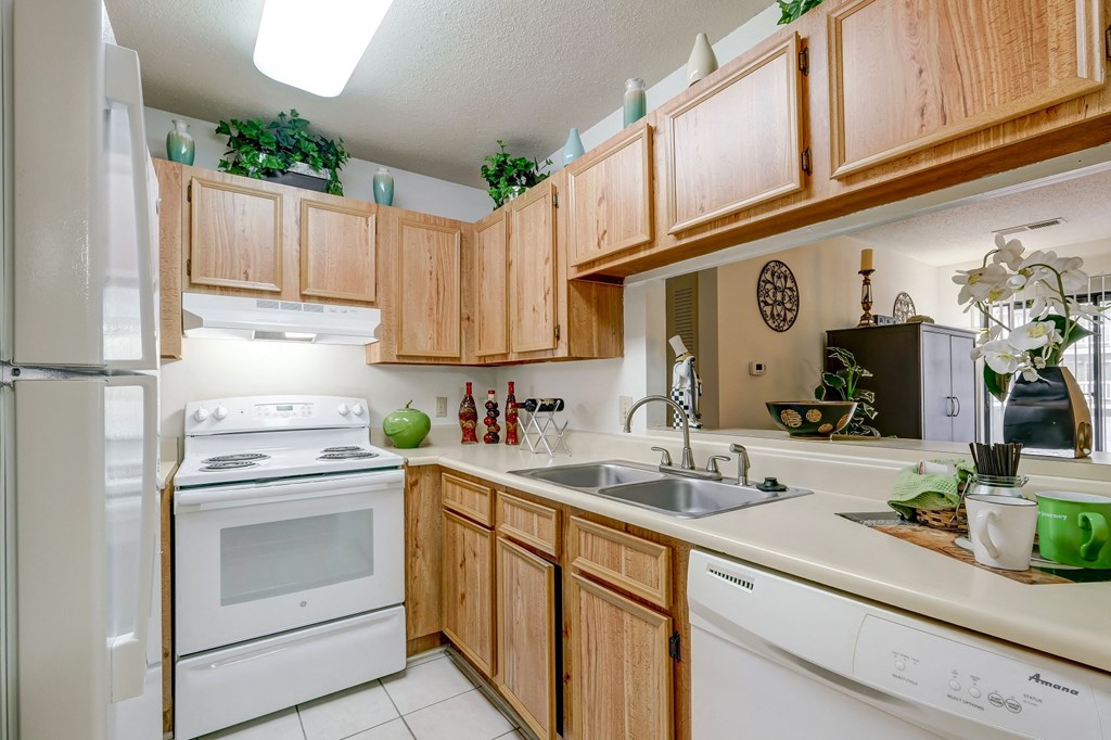 a kitchen with white appliances and wooden cabinets