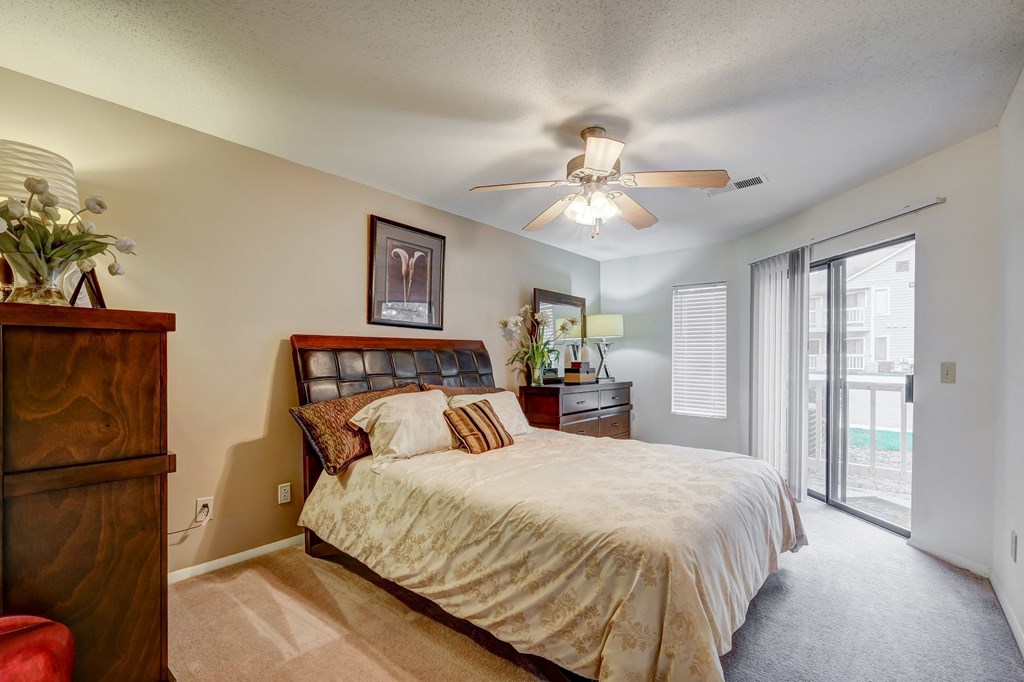 a bedroom with a large bed and a ceiling fan