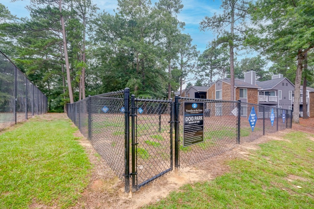 a fenced in yard with a chain link fence and a house behind it