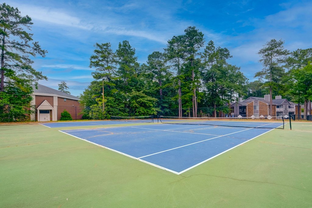 the tennis court at the community is equipped with a blue and green court with a