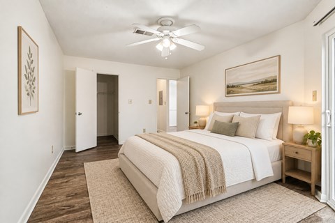 A bedroom with a large bed and a ceiling fan.