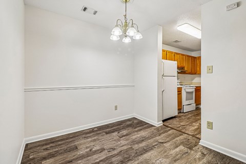 A kitchen with a white fridge and wooden cabinets.