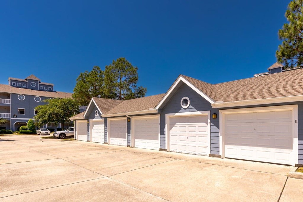 a row of garages with white doors in front of a building