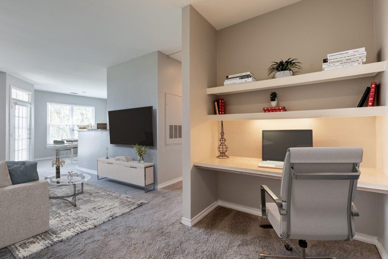 a home office with a desk and a television