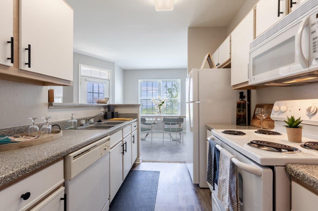 a kitchen with white cabinets and a stove and a sink