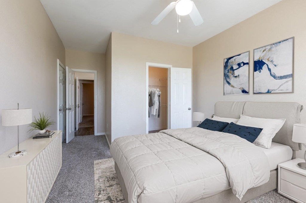 a bedroom with a white bed and a ceiling fan