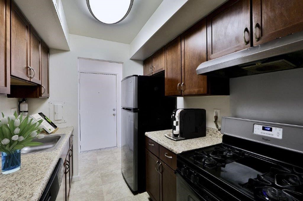 a kitchen with a stove and refrigerator and a sink