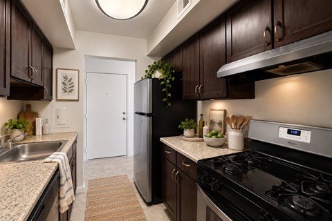 A kitchen with a black stove top oven and a white refrigerator.
