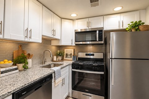 A modern kitchen with stainless steel appliances and white cabinets.