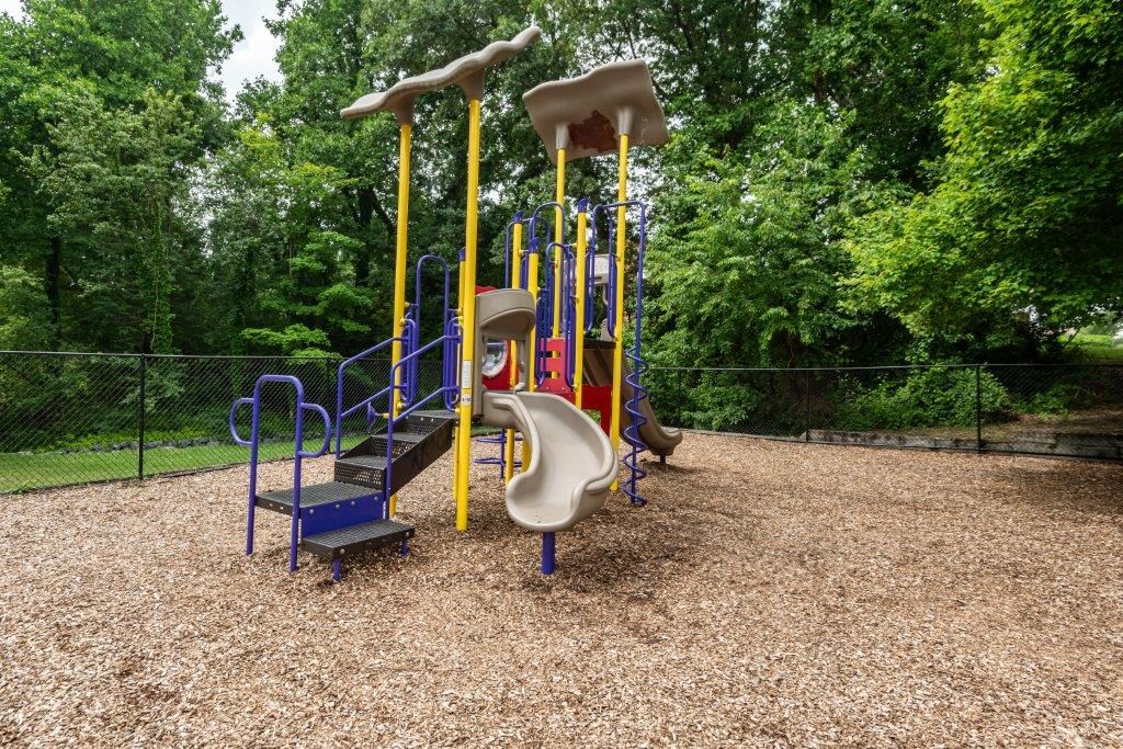 a playground with colorful slides and trees in the background