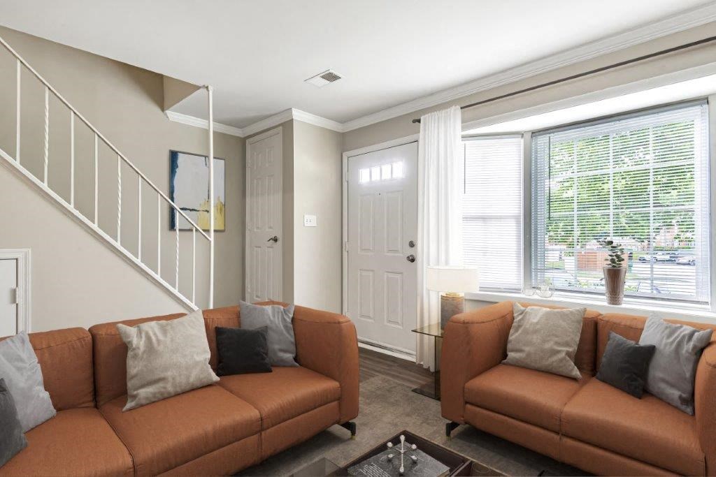 a living room with brown couches and a window