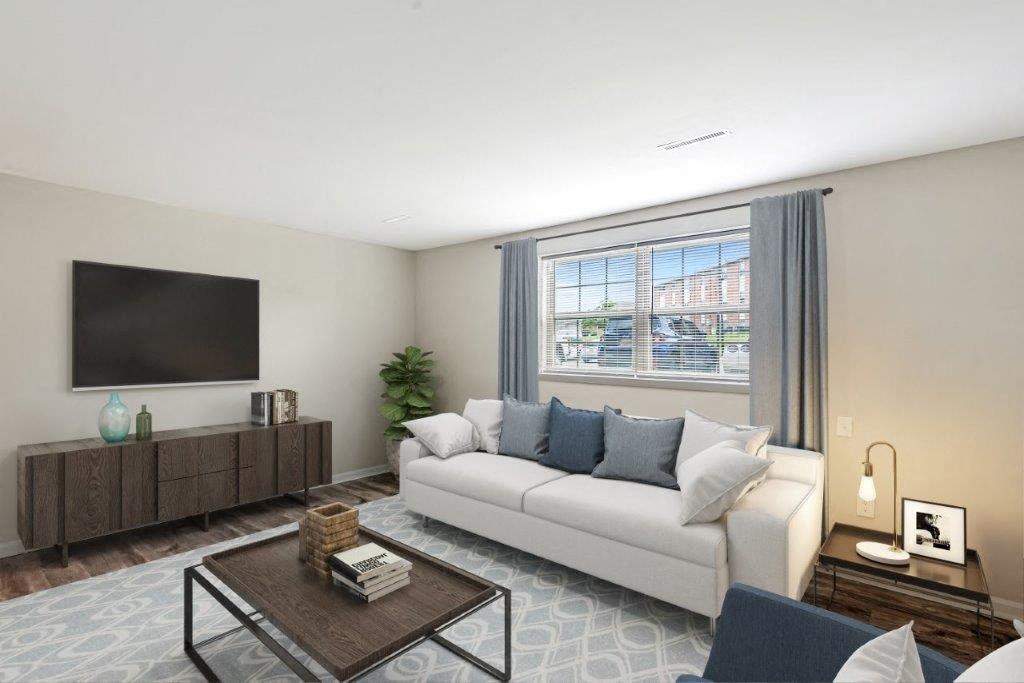 a living room with a white couch and a television