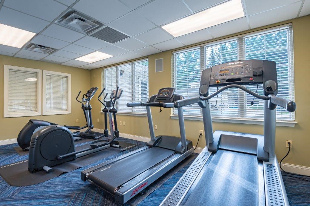 a gym with exercise machines and windows