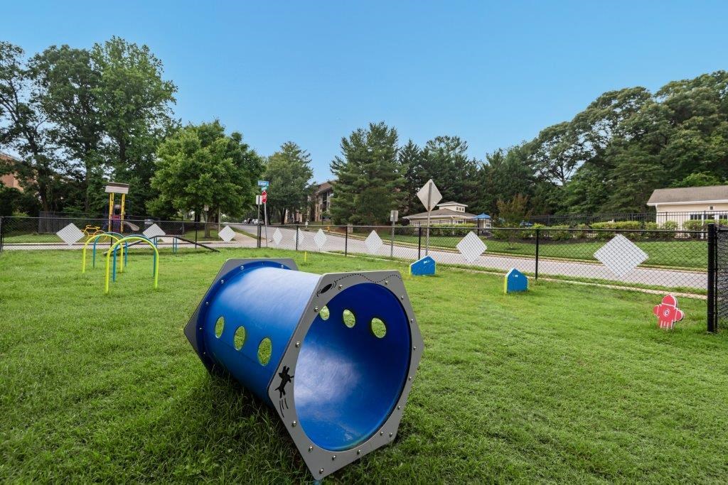 a playground with a blue barrel on the grass