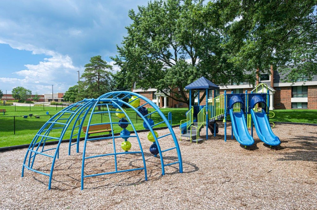 A playground with a blue swing set and a blue slide.