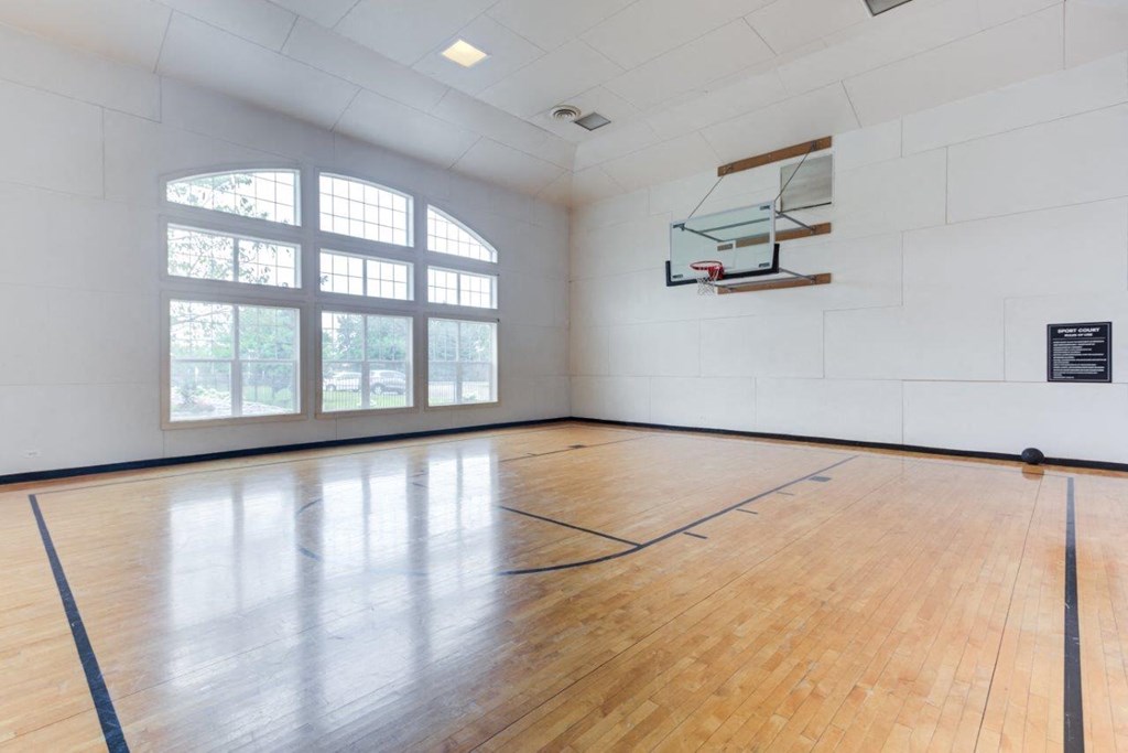 an empty gym with a wooden floor and a window