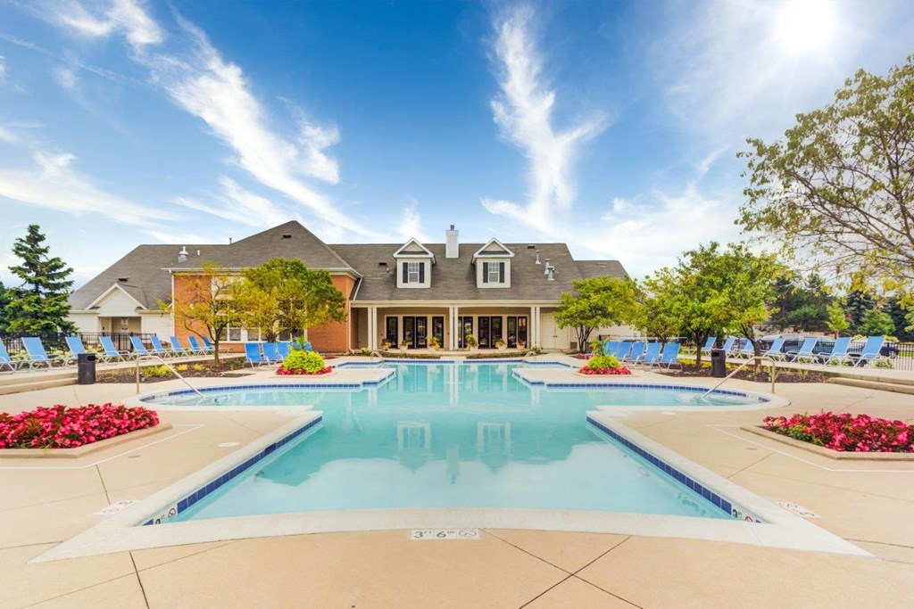 a large swimming pool with a house in the background